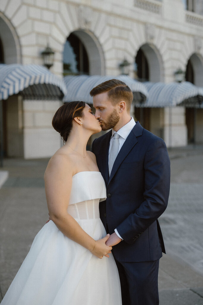 Couple sharing a quiet kiss outside San Francisco City Hall, part of a San Francisco City Hall wedding private ceremony room day. 
