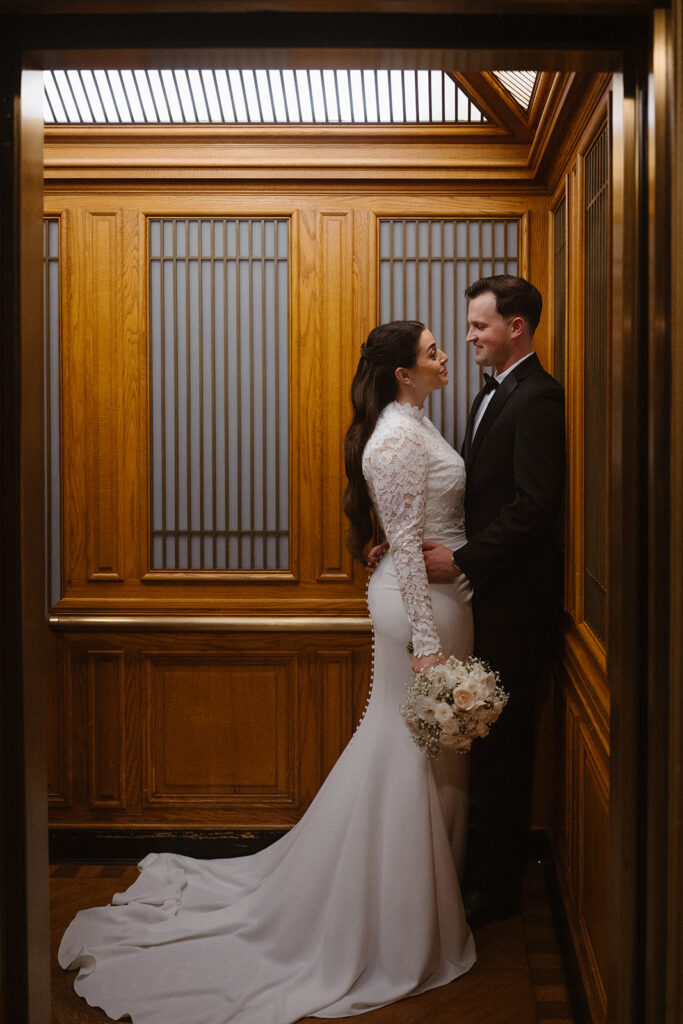 Bride and groom sharing a quiet moment inside an elevator during their SF city hall wedding ceremony. 
