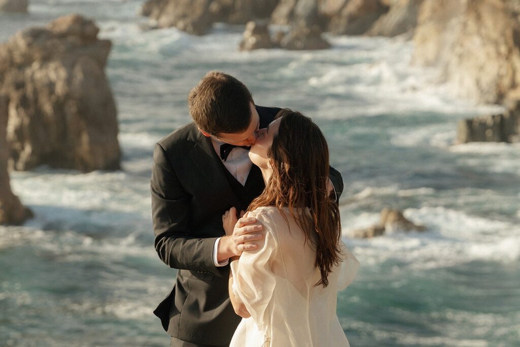 Couple embracing with ocean waves during Big Sur elopement