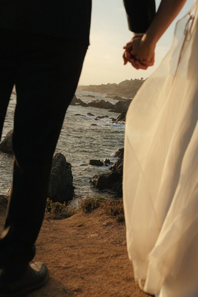 Couple holding hands with ocean view during Big Sur elopement