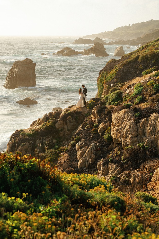 Big Sur elopement couple standing along rugged coastal cliffs
