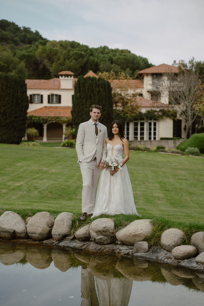 Bride and groom posing by the reflecting pond at one of the most elegant San Francisco intimate wedding venues in the Bay Area.