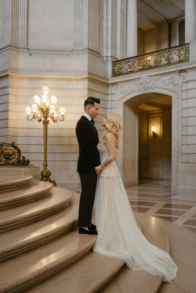 Elegant wedding portrait on the grand staircase inside a small wedding venue San Francisco couples choose for timeless architecture.