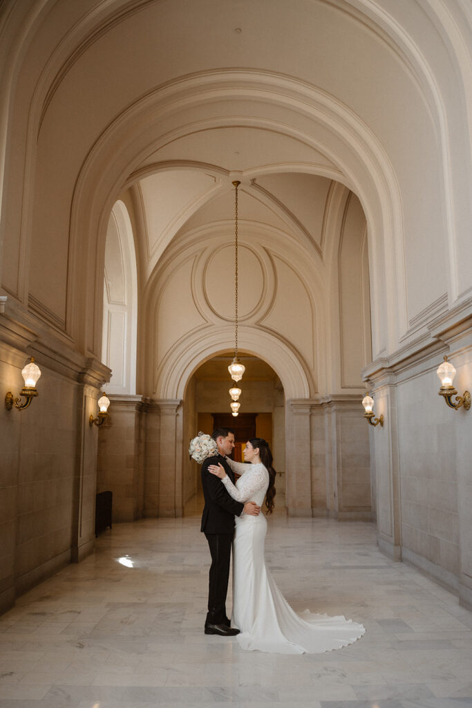 Bride and groom embracing beneath the marble arches inside a small wedding venue San Francisco couples love for intimate celebrations.