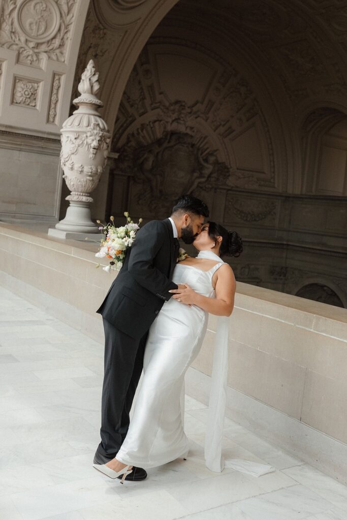 A groom kisses his bride after they get married in City Hall