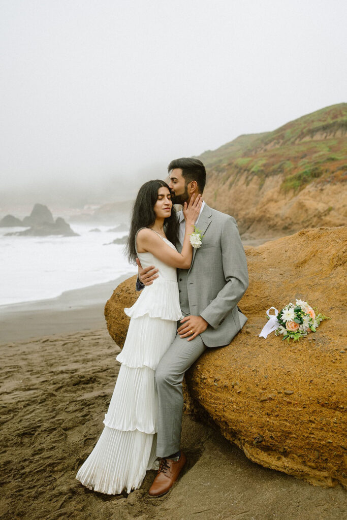 Couple embracing at the beach at their Marin Headlands intimate wedding